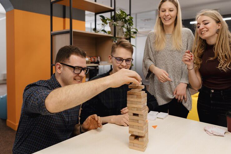 Quizizz: mixed team playing blocks wood game in the office