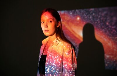 Colors-of-Emotion: young woman standing in universe texture projection
