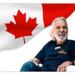 Tommy Chong Net Worth, canada flag in background, a man is sitting in front in happy mood