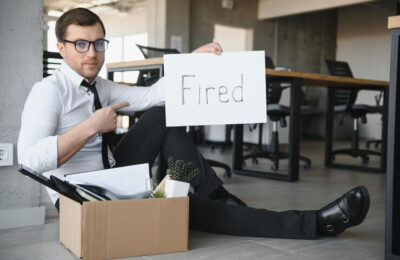 Twilio Layoffs, fired employee holding fired sign in hand