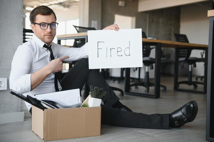 Twilio Layoffs, fired employee holding fired sign in hand