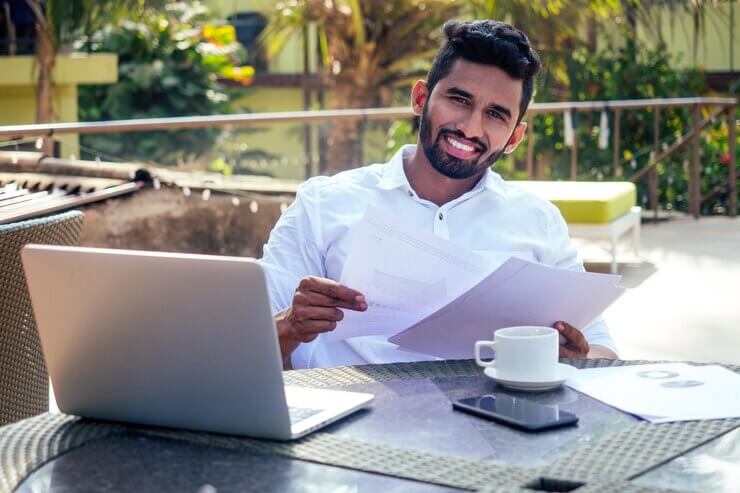 andsome and successful indian man in a stylish welldressed freelancer working with a laptop