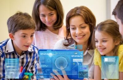 Education, elementary school, learning, technology and people concept - group of kids with teacher looking to tablet pc computer in classroom over virtual screens projections