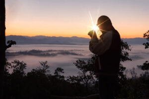 man sitting in a land at the tim of sun rising