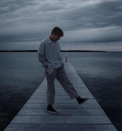 A man standing beside sea in depression