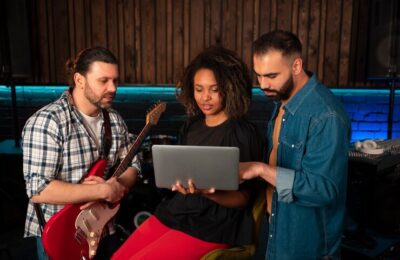 Medium shot musicians working with laptop