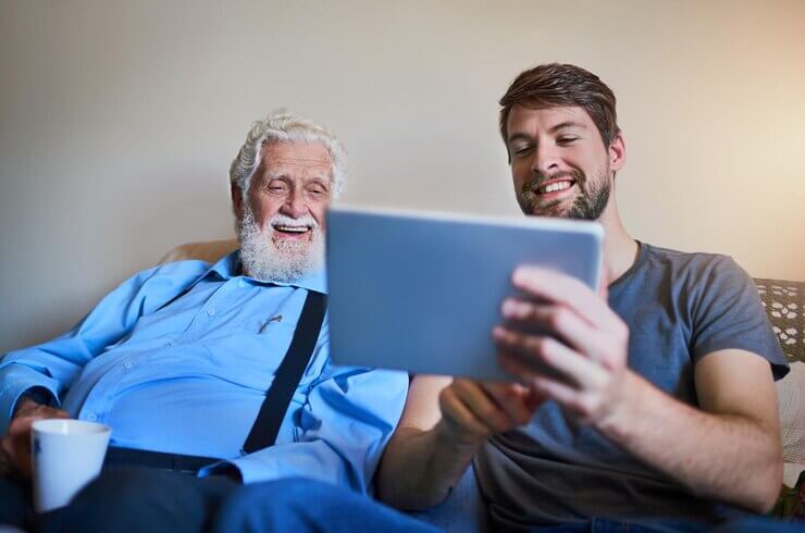 Welcoming grandpa to the age of technology shot of a young man showing his elderly grandfather