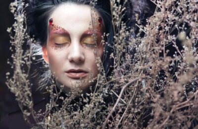 Woman with bright make up with dry branches