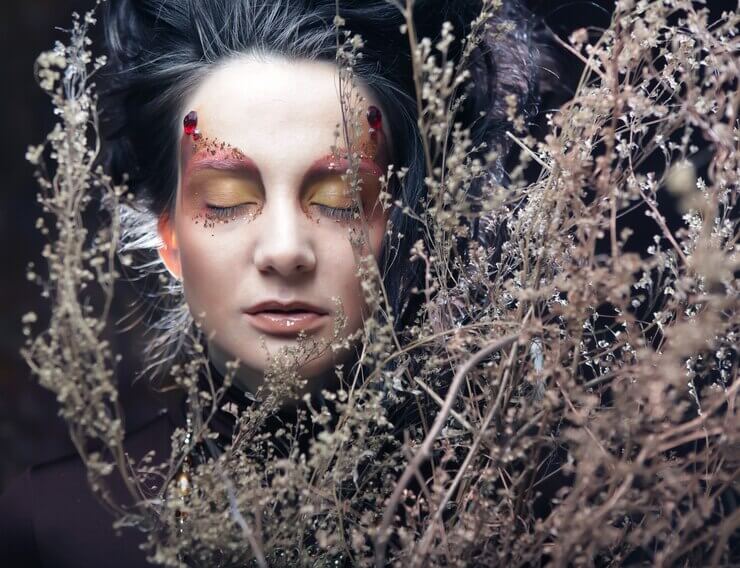 Woman with bright make up with dry branches