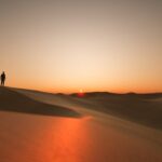 Dunes at sunset with a silhouette of a person