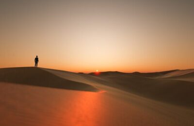 Dunes at sunset with a silhouette of a person