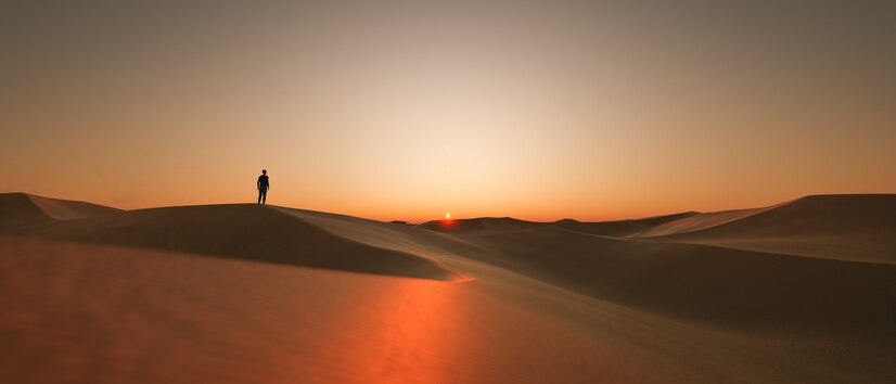 Dunes at sunset with a silhouette of a person