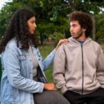 Sad couple sitting together outdoors