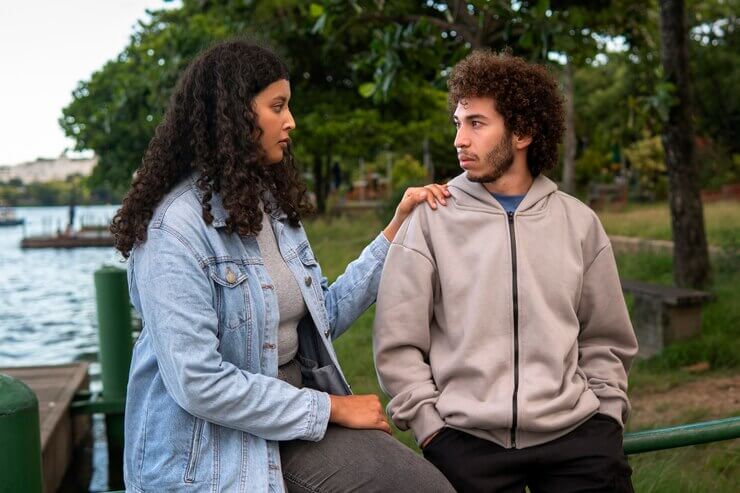 Sad couple sitting together outdoors