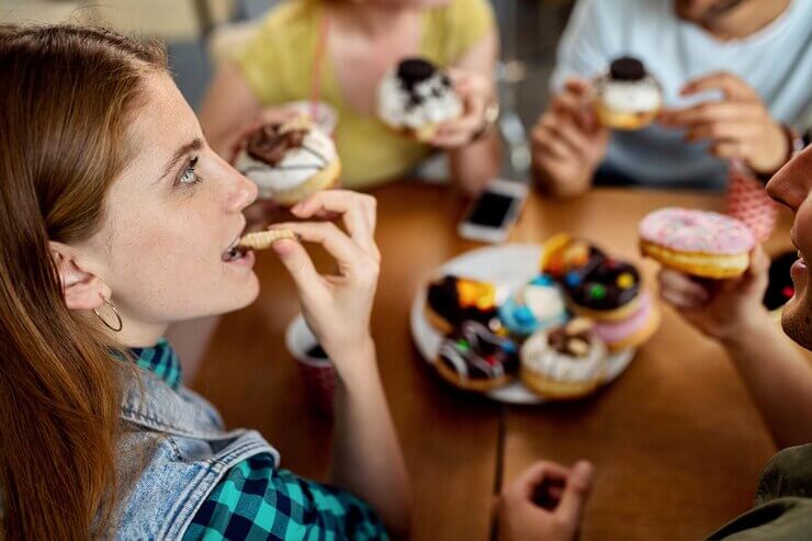 Girl enjoying donut with friends
