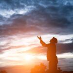 Silhouette of handsome asian man praying.