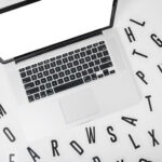 Elevated view of laptop with various alphabets on white background