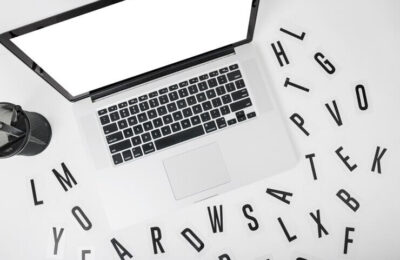 Elevated view of laptop with various alphabets on white background