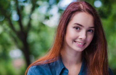 Teenage redhead girl smiling outside