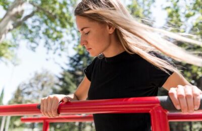 Woman holding herself on a metal bar