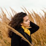 Young beautiful woman in nature with camera