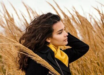 Young beautiful woman in nature with camera