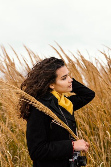 Young beautiful woman in nature with camera