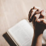 Hands bound on a book for prayer