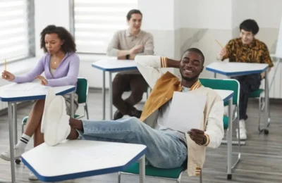 Student Resting his Feet on Top of his Desk