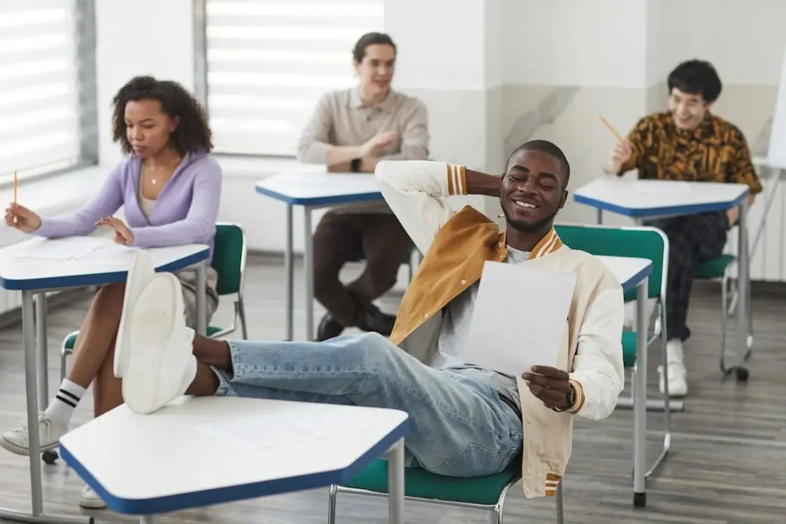 Student Resting his Feet on Top of his Desk