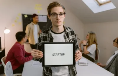 Man in Black and White Plaid Long Sleeves Holding a Tablet Computer