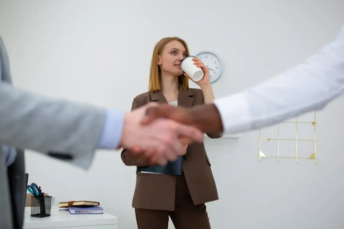 A Woman in Gray Blazer Holding a White Coffee Cup