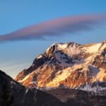 A mountain range with a cloud in the sky