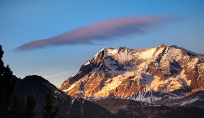 A mountain range with a cloud in the sky