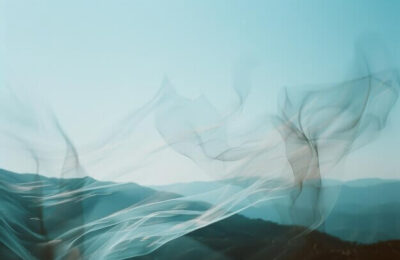 delicate-sheer-fabric-dances-wind-against-backdrop-mountains-creating-artistic-ethereal-impression-nature-movement-soft-blue-skies