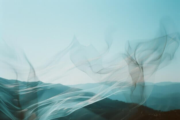 delicate-sheer-fabric-dances-wind-against-backdrop-mountains-creating-artistic-ethereal-impression-nature-movement-soft-blue-skies