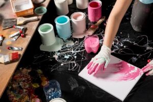 High angle of painter with canvas and cans of paint