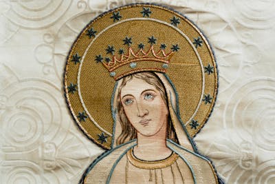 Woman painting in White and Black Stripe Shirt. Wearing a crown also