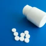 Medicine Tablets Beside a Plastic Container