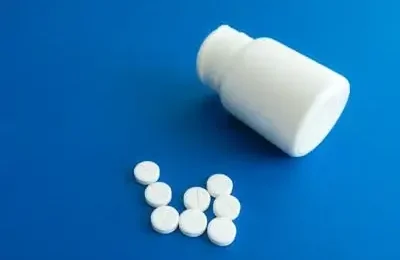 Medicine Tablets Beside a Plastic Container