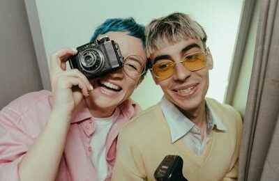 Man in Brown Button Up Shirt Holding Black and Silver Camera