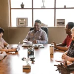 People Sitting Around Wooden Table