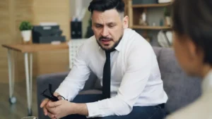 A man sitting on a couch talking to a woman