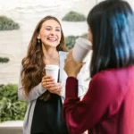 2 Women Holding Drinking Glasses