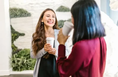 2 Women Holding Drinking Glasses