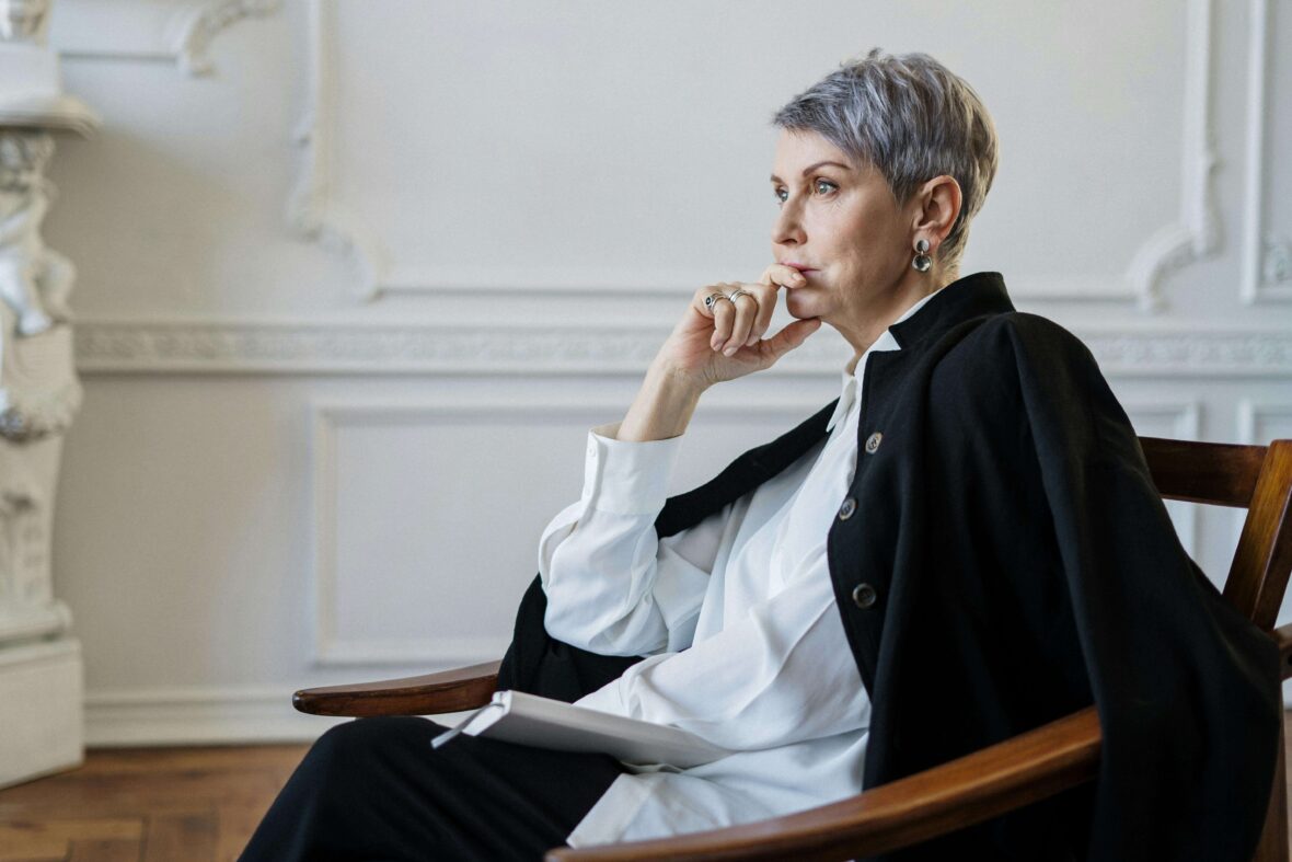 Woman in Black Blazer Sitting on Chair