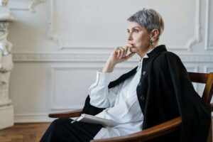 Woman in Black Blazer Sitting on Chair