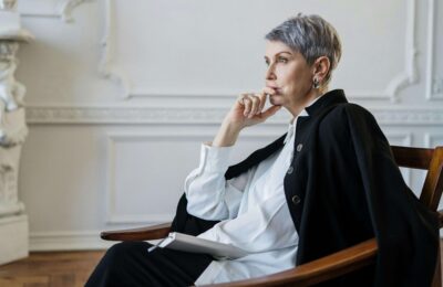Woman in Black Blazer Sitting on Chair