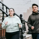 Plus sized female running with Asian man on street in daytime