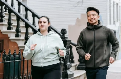 Plus sized female running with Asian man on street in daytime